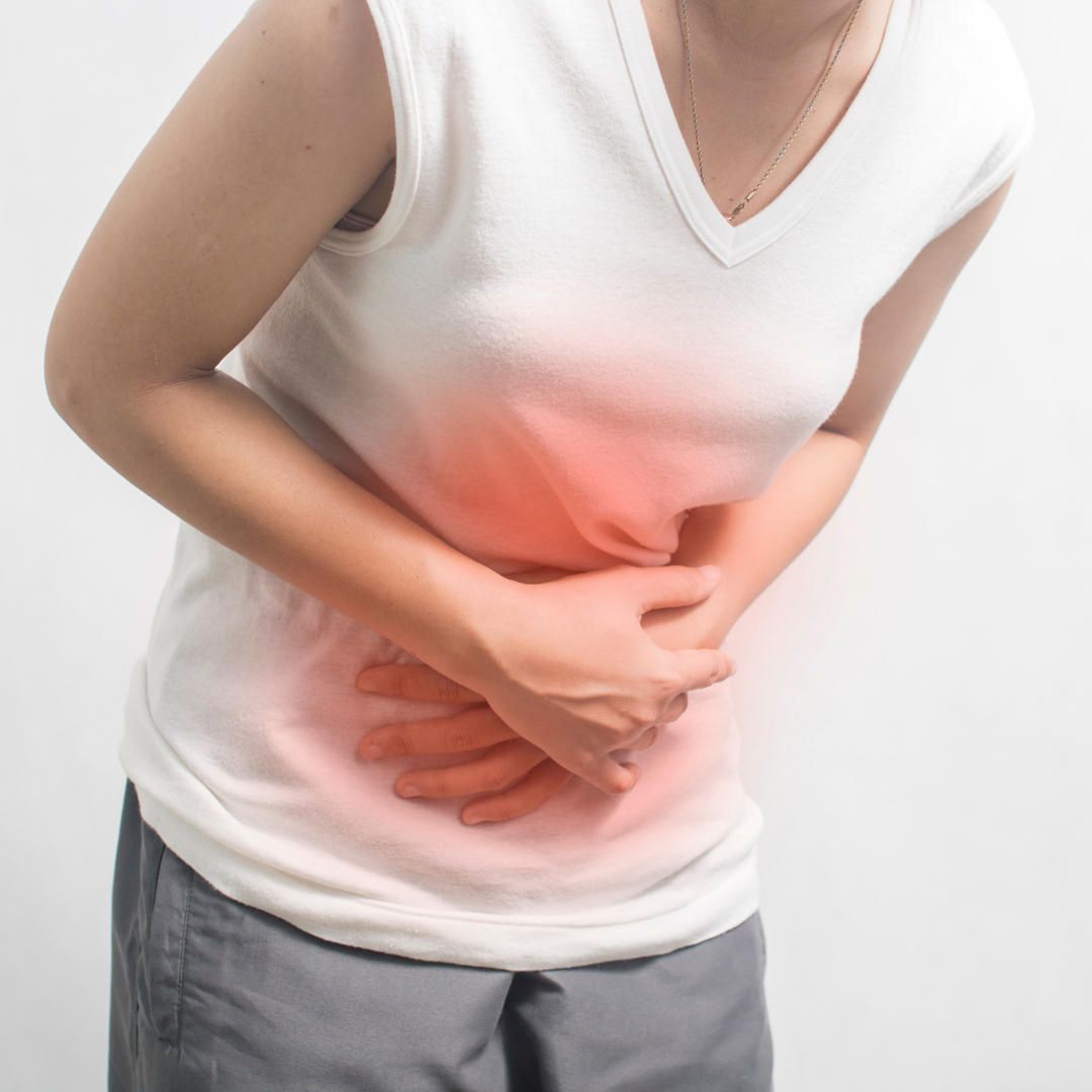 Person clutching stomach in pain, with a red area indicating discomfort or abdominal pain.